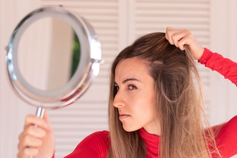 Woman looking at scalp in mirror